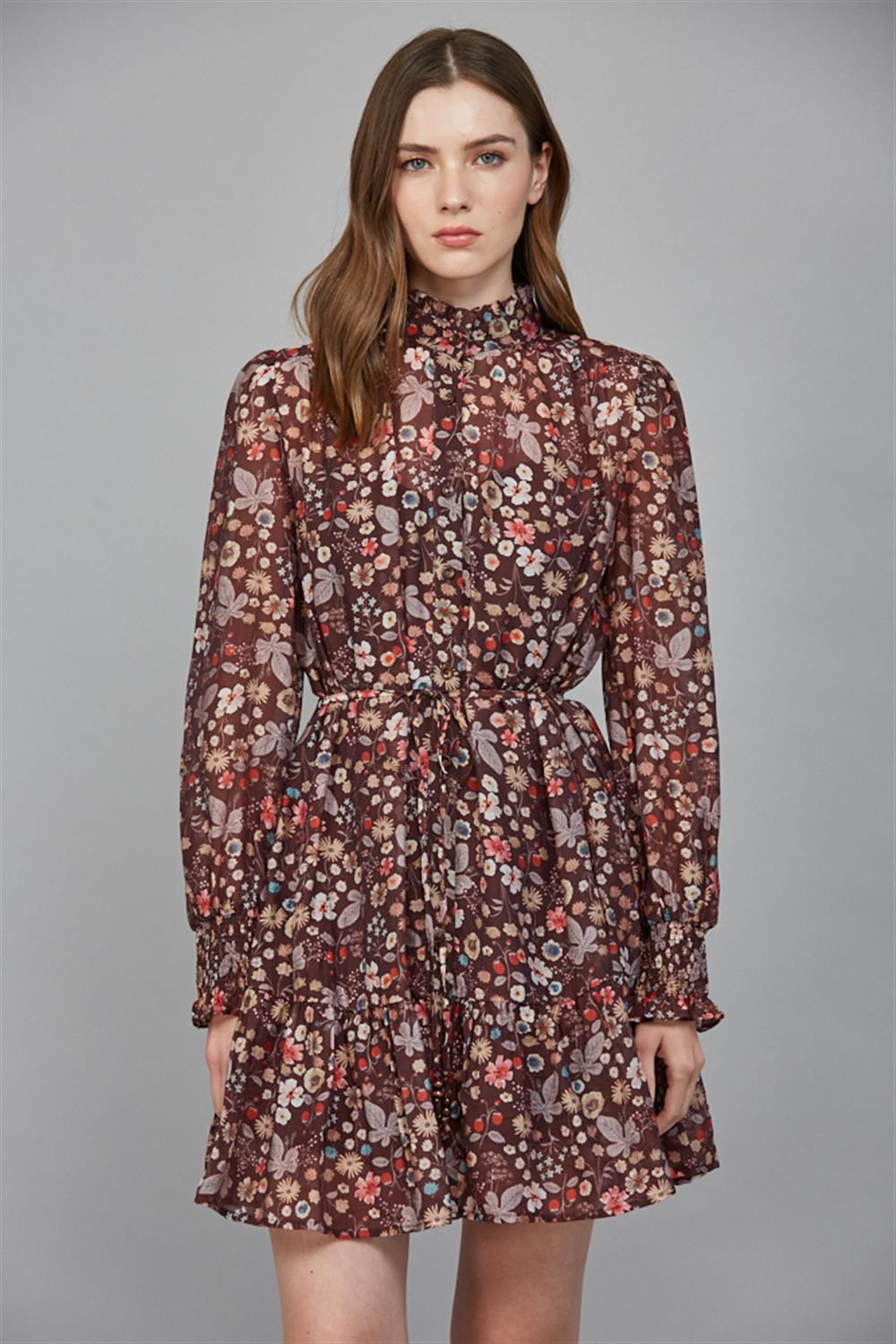 Brown ditsy floral print dress with high ruched mock neckline, long sleeves with ruffled cuffs, tie waist, gathered A-line skirt, and ruffle hem detail.