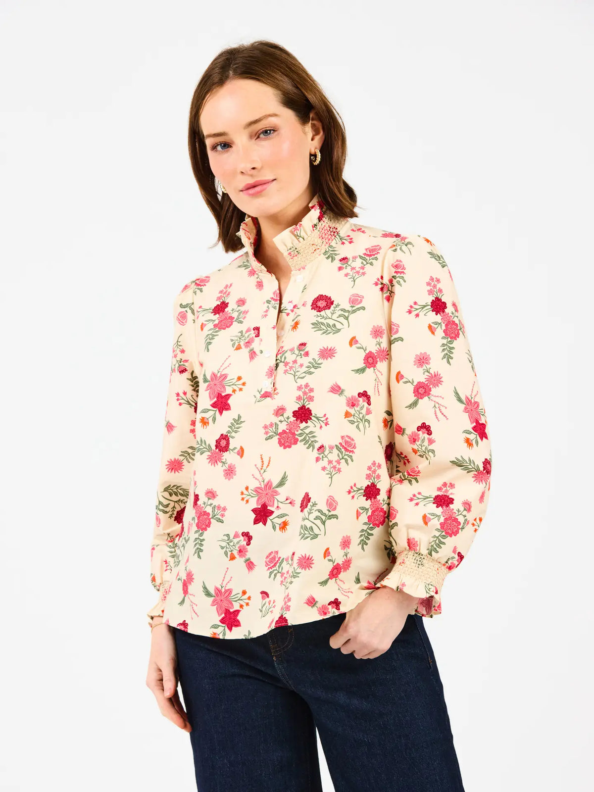 Cream long-sleeve button-up blouse with multicolor botanical floral print, collared neckline, gathered cuffs, and relaxed hip-length silhouette.
