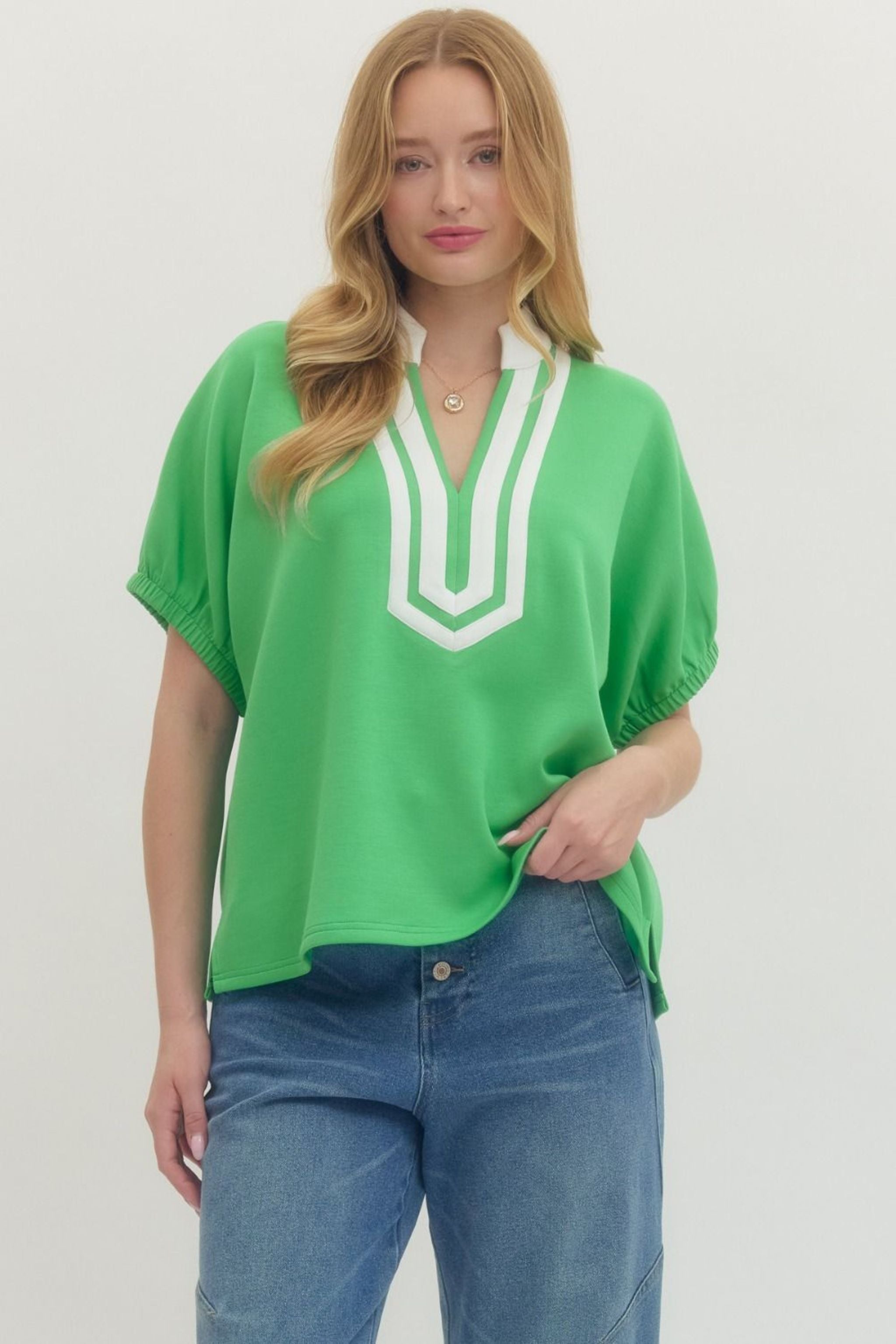 Woman wearing a green blouse with white neckline design