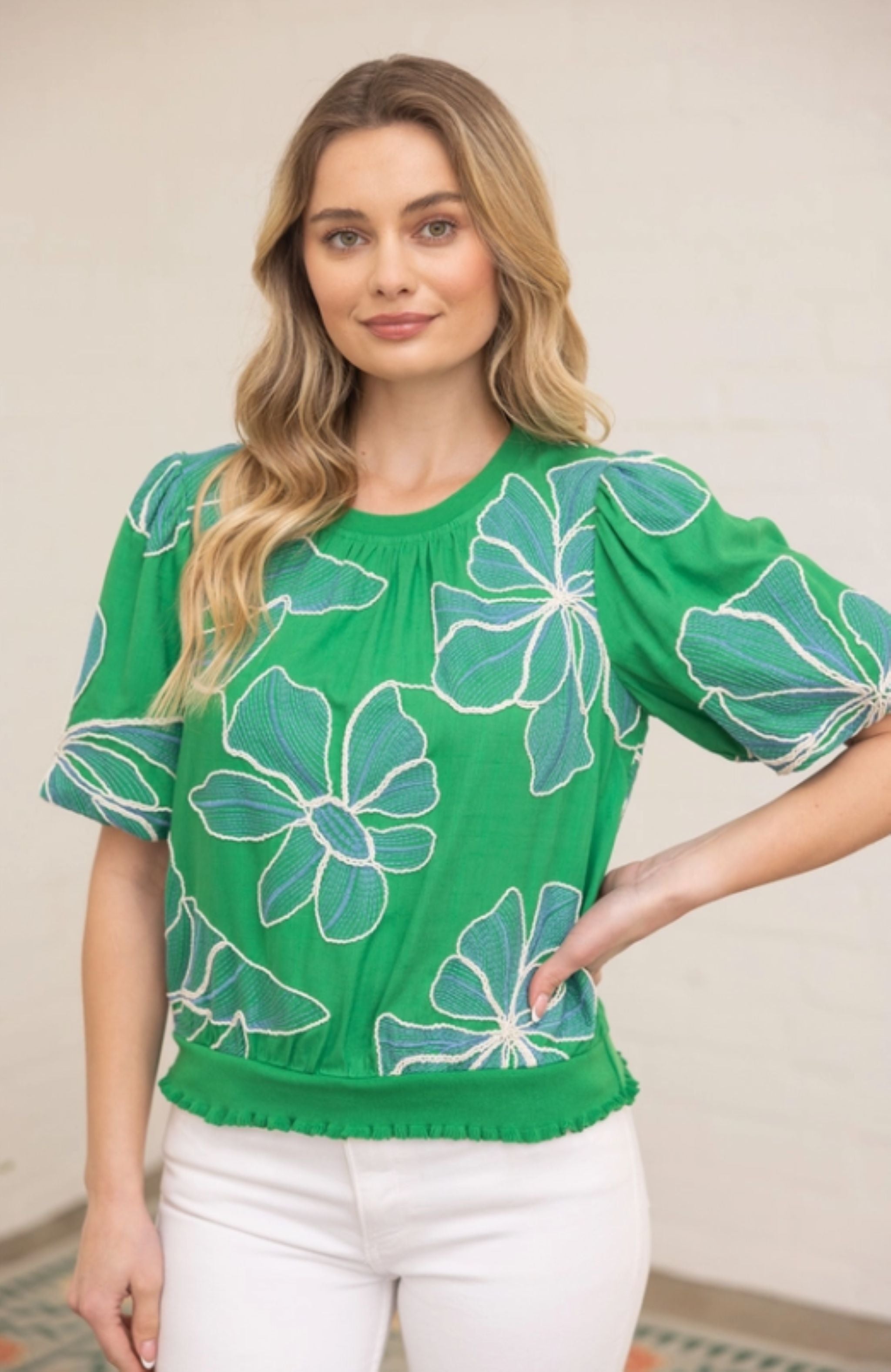 Woman wearing a green blouse with floral patterns