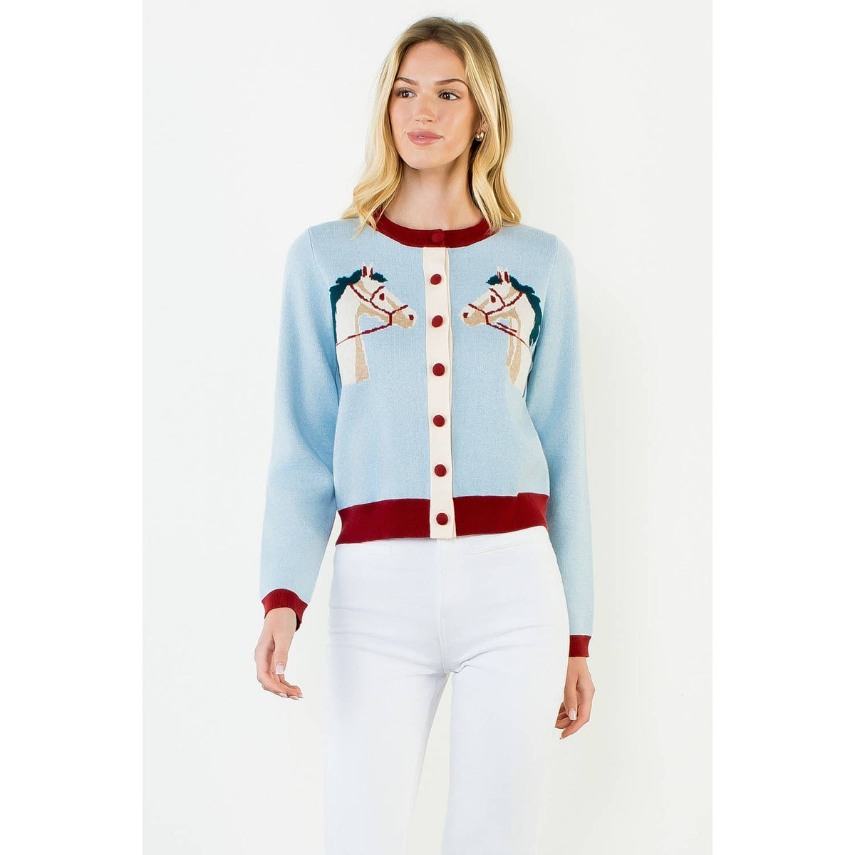 Model wearing a light blue knit cardigan with twin horse motifs, burgundy trim and buttons, and a cream button placket.
