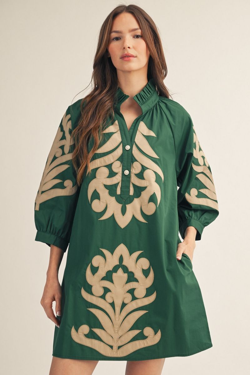 Make a statement in this hunter green mini dress, featuring intricate tan appliqué medallion motifs throughout the bodice, skirt, and balloon sleeves.