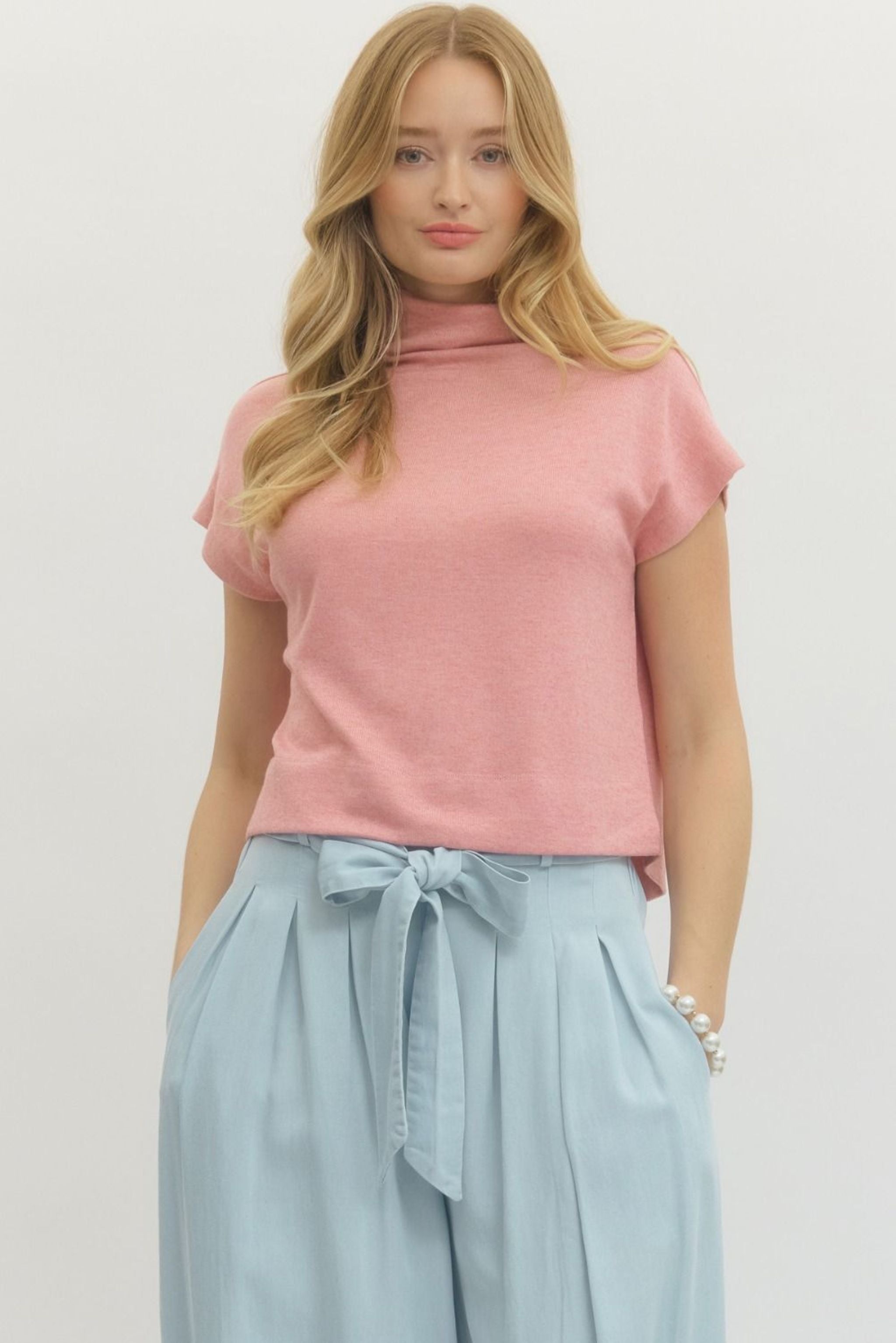 Woman wearing a pink mock neck top