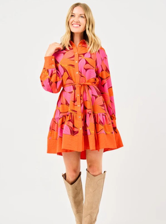 Woman wearing a bright orange and pink floral dress