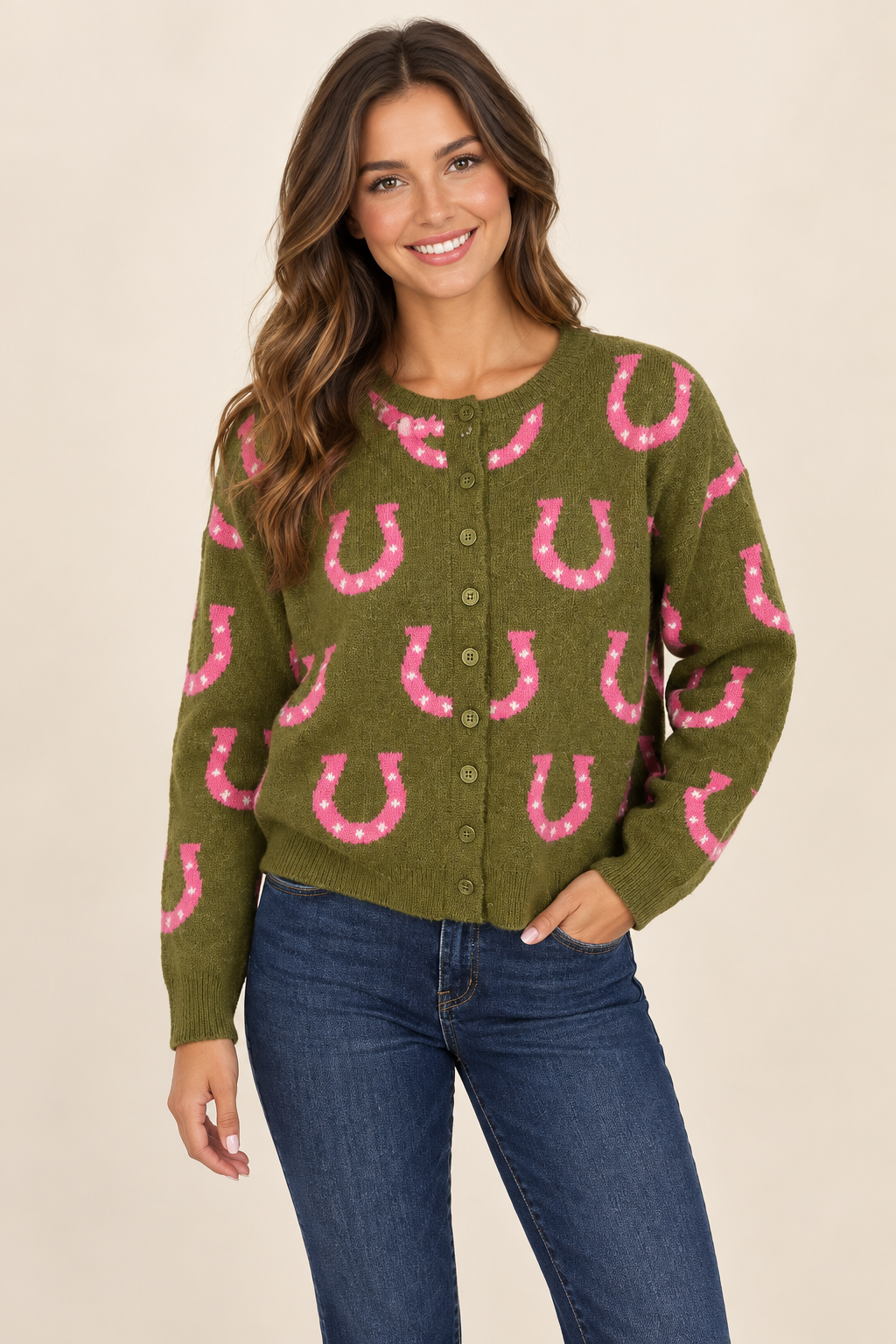 Model wearing an olive green button-front sweater with pink horseshoe details against a neutral studio background