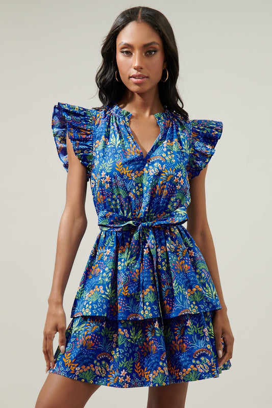 A multi color floral print that lays against a cobalt ground. It decorates ruffle cap sleeves to frame a split neckline. 