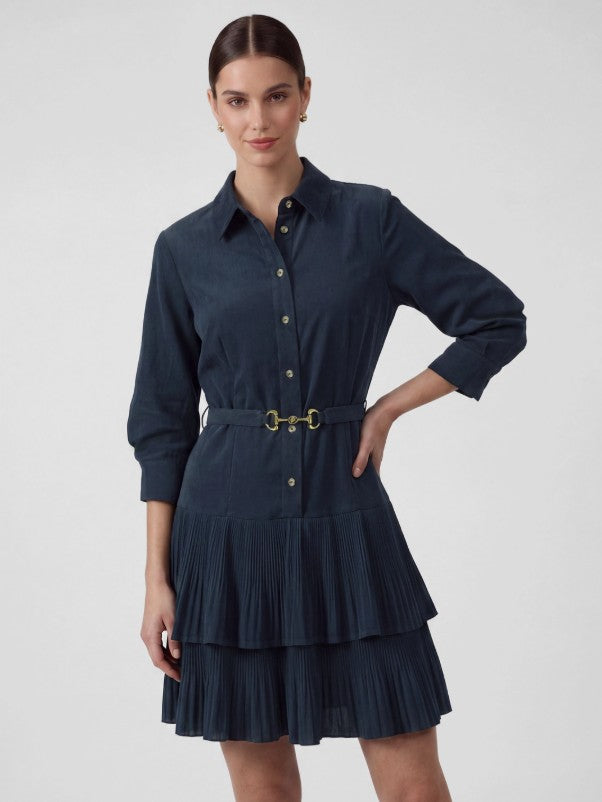 Dark indigo corduroy mini shirt dress with classic collar neckline, front button closure, gold-tone horsebit buckle belt, three-quarter sleeves, and two-tiered pleated mini skirt.