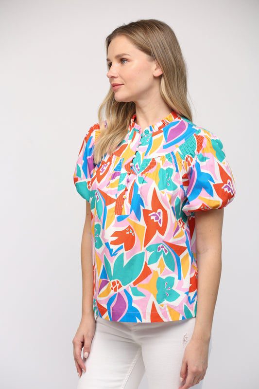 Turn heads with this multi-colored smocked bib short sleeve top. 