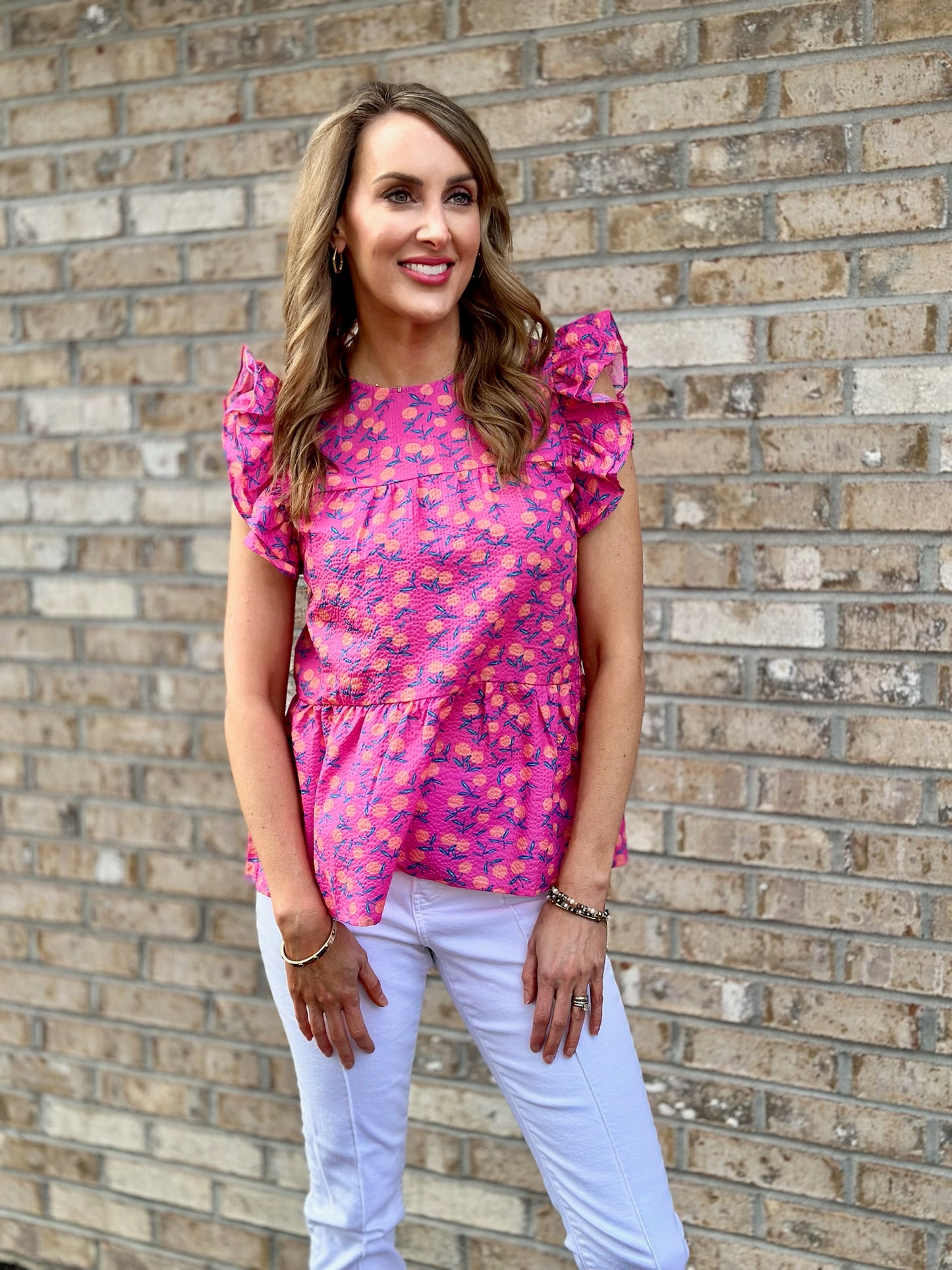 A timeless ruffle sleeve blouse that will never go out of style. Seersucker-like fabrication gives this pink floral top an adorable look for work or play. 