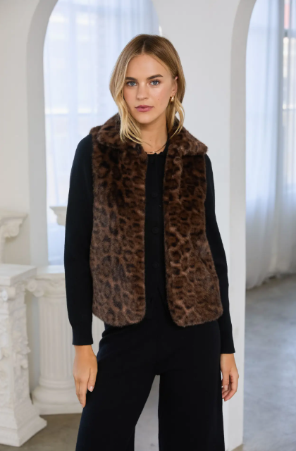 Leopard faux fur vest styled over a black knit — open-front plush vest with leopard print
