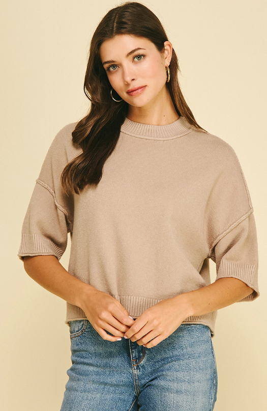 Tan crop knit strikes the perfect balance between cozy and put-together, with a drop shoulder silhouette and mock neckline that feel relaxed without looking casual. 