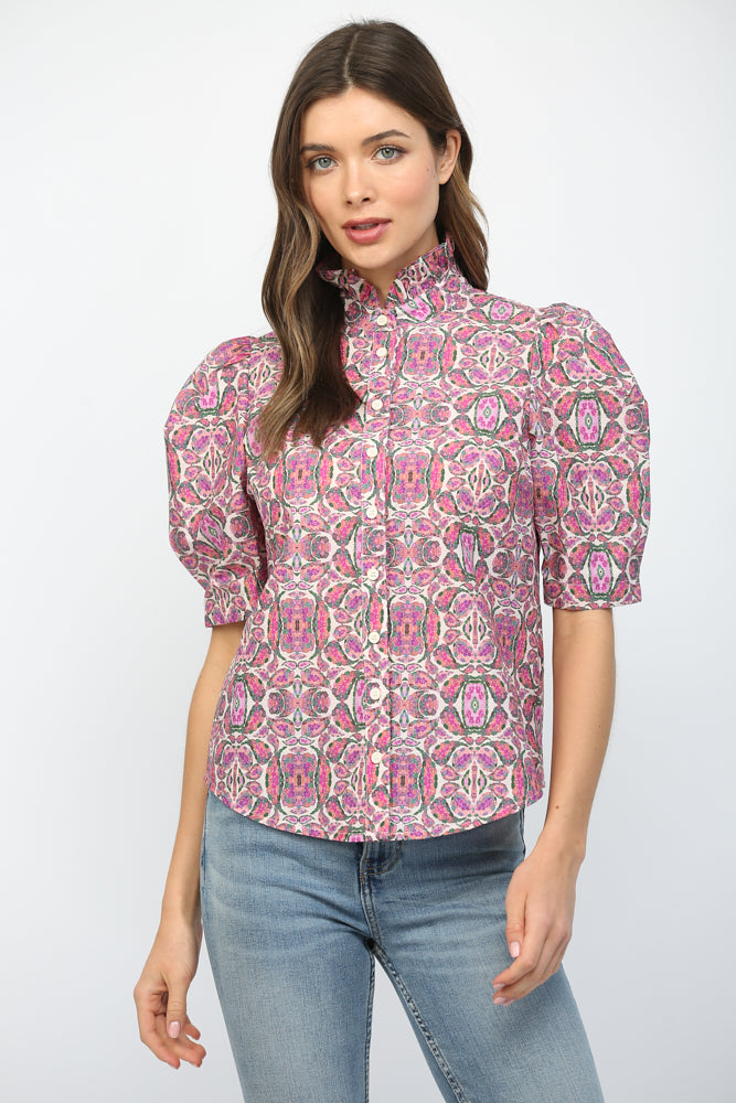 Woman wearing a pink patterned blouse and blue jeans 