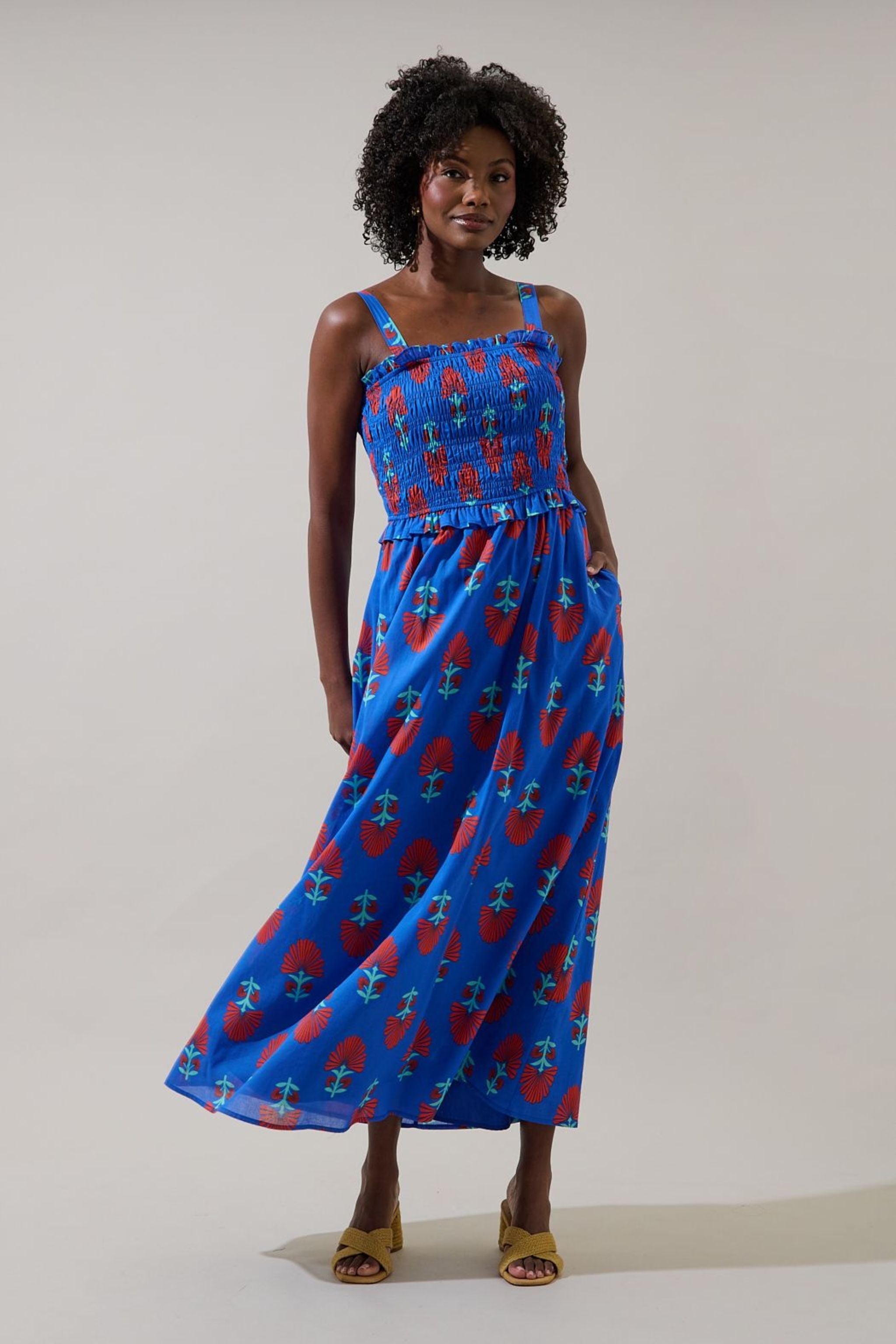 Woman wearing a blue dress with red patterns