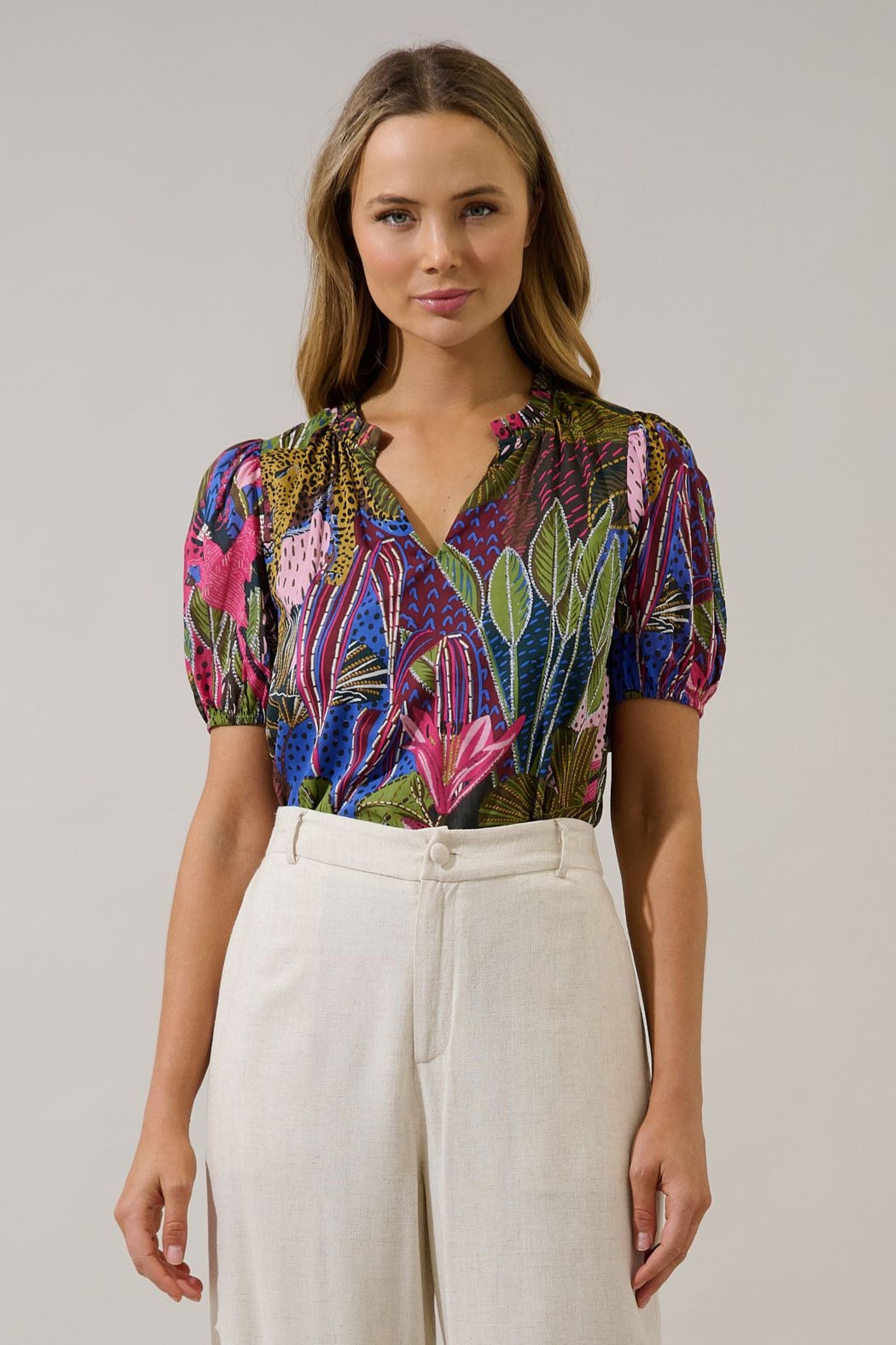 Woman wearing a colorful patterned top with white pants